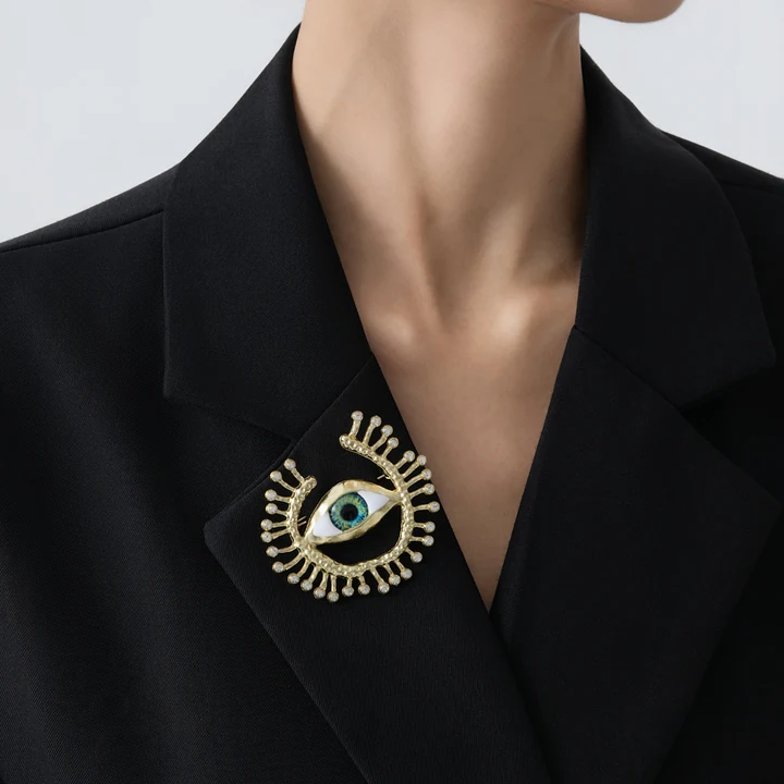 Radial eye brooch shown in worn / black tailoring