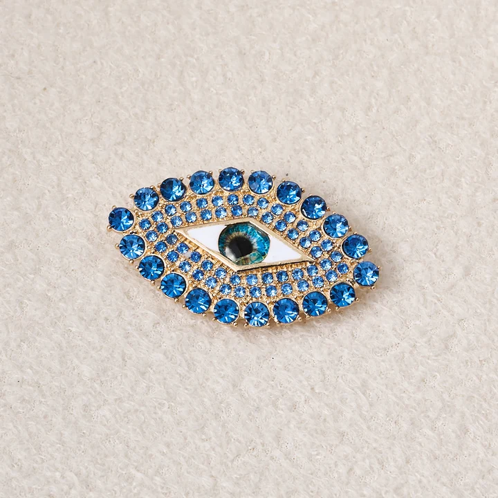 blue eye brooch shown in pale textile